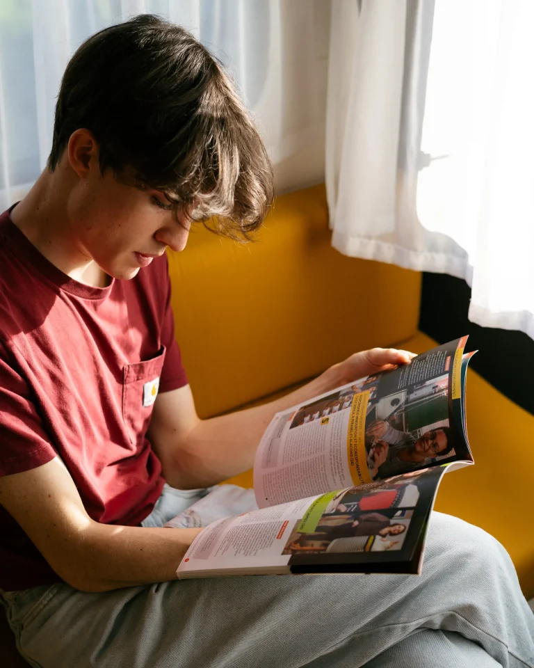 Un adolescent consulte une brochure de formation pendant sa séance d’orientation